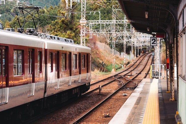 Regionalzug an einem Bahnsteig mit Weichen und elektrischer Oberleitung