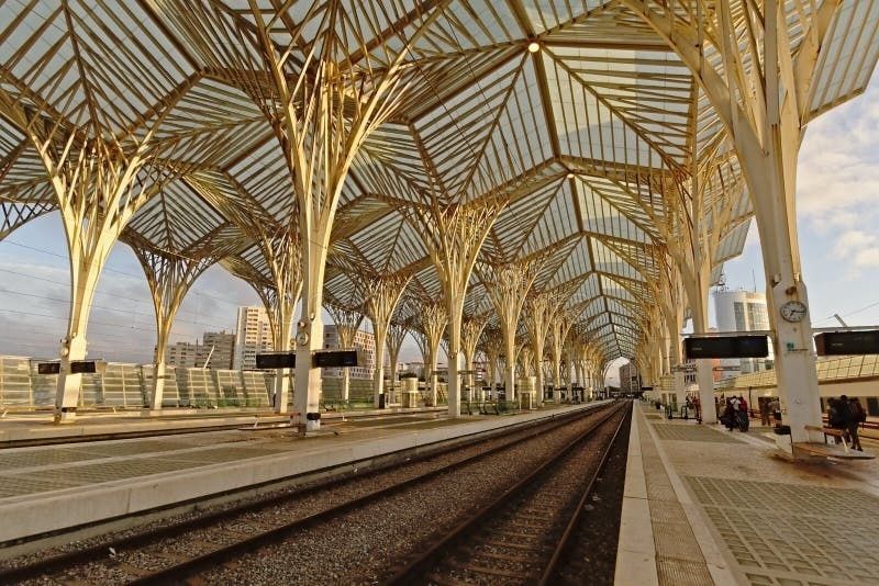 Moderner Bahnhof mit weit gespannter Stahl-Glas-Dachkonstruktion und Bahnsteigen